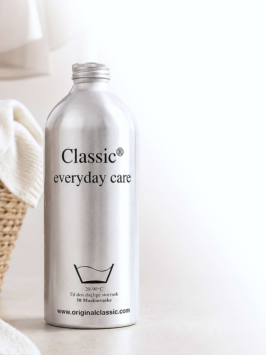 Classic everyday care-flaske med vasketøjskurv i baggrunden
